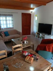 ein Wohnzimmer mit einem Tisch und einem Sofa in der Unterkunft 4 seasons in Lávrio