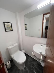 a bathroom with a white toilet and a mirror at Great apartment in the heart of Coyoacan in Mexico City