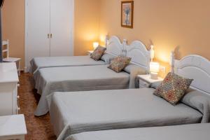 Cette chambre comprend quatre lits et un canapé. dans l'établissement Sanvi Xerez Centro, à Jerez de la Frontera