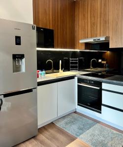 a kitchen with white appliances and wooden cabinets at PRIMO Premium Apartments Łódź Fabryczna in Łódź
