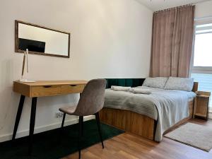 a bedroom with a bed with a desk and a chair at PRIMO Premium Apartments Łódź Fabryczna in Łódź