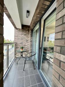 a patio with a table and a chair on a balcony at PRIMO Premium Apartments Łódź Fabryczna in Łódź