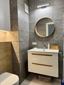 a bathroom with a sink and a mirror at PRIMO Premium Apartments Łódź Fabryczna in Łódź