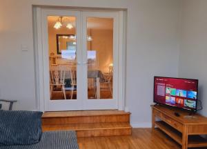 een woonkamer met een glazen schuifdeur bij Captivating & Cosy 4-Bedroom House in Magherafelt in Magherafelt