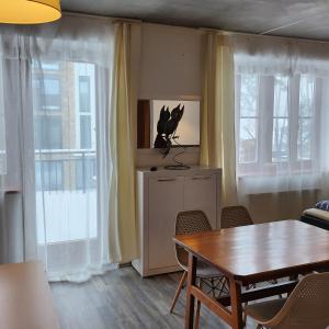 a living room with a table and chairs and windows at Ubytování u Maxe in Lipno nad Vltavou