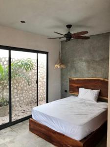 1 dormitorio con 1 cama y ventilador de techo en Condominio Pacha en Tulum, en Tulum