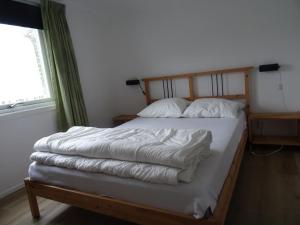 a bedroom with a bed with white sheets and a window at Björkdahla in Dörarp