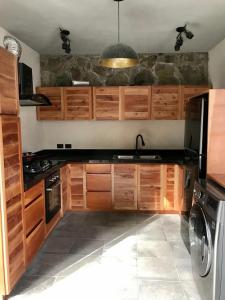 una cocina con armarios de madera y fregadero en Condominio Pacha en Tulum, en Tulum
