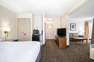 a hotel room with a bed and a television at Ramada by Wyndham Kamloops in Kamloops