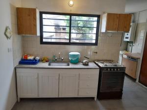 cocina pequeña con fregadero y fogones en Las Calandrias 2 dormitorios en Villa Carlos Paz