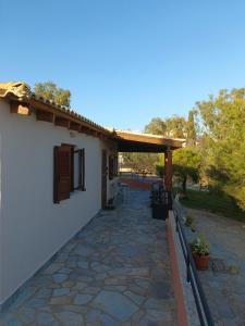 eine Terrasse eines Hauses mit einer Pergola in der Unterkunft 4 seasons in Lávrio