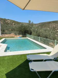 a swimming pool with two lounge chairs next to it at Appartement Villa Pasithea in Xiropigado