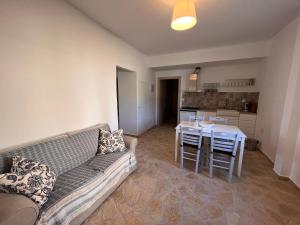 a living room with a couch and a table with chairs at Appartement Villa Pasithea in Xiropigado