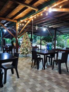 Hotel Campo Verde في فيلاجارزون: مطعم بطاولات وكراسي وشجرة عيد الميلاد
