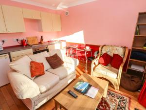 uma sala de estar com um sofá branco e uma mesa em Cwtch Cowin em Banc-y-felin