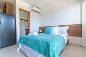 a bedroom with a large bed with a blue blanket at Mana Beach #B217 - Quadrúplo por Carpediem in Porto De Galinhas