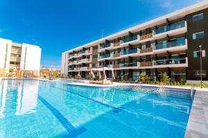 a large swimming pool in front of a building at Mana Beach #B217 - Quadrúplo por Carpediem in Porto De Galinhas