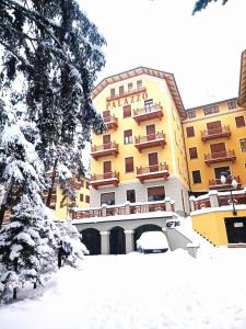 a large yellow building with snow in front of it at 4th Floor Bardonecchia in Bardonecchia