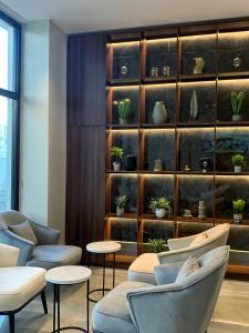 a waiting area with chairs and tables and a shelf with potted plants at فندق اسين in Al Madinah