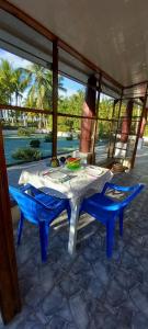 a table and two blue chairs on a patio at Maison du Bonheur CABALLO DEL MAR à 2 minutes de la PLAGE in Parrita