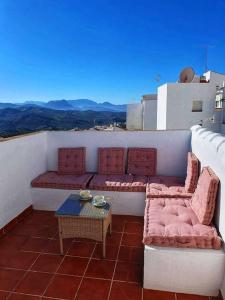 einen Balkon mit Sofas und einem Tisch auf dem Dach in der Unterkunft Olive Tree self-catering accommodation in Olvera