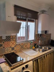 a kitchen counter with a sink and a window at Olive Tree self-catering accommodation in Olvera