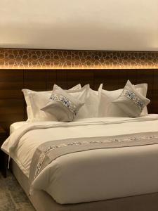 فندق اسين في المدينة المنورة: سرير أبيض كبير عليه وسائد بيضاء
