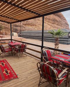 d'une terrasse avec des tables et des chaises offrant une vue sur la montagne. dans l'établissement MOHAMMED ZAWAIDAH CAMP, à Wadi Rum