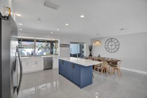 a large kitchen with a blue island and a table at Tropical Escape - Heated Pool - Game Room in Hollywood
