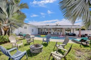 a backyard with chairs and a fire pit and a house at Tropical Escape - Heated Pool - Game Room in Hollywood