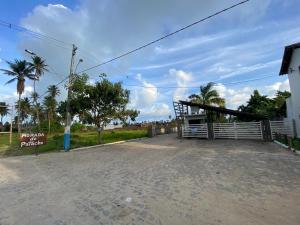 um parque de estacionamento com um portão e palmeiras em Kaha Mar - Patacho em Porto de Pedras
