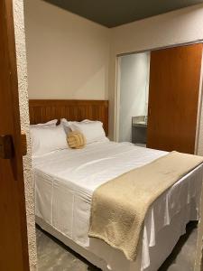 um quarto com uma grande cama branca e uma cabeceira em madeira em Kaha Mar - Patacho em Porto de Pedras