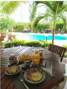 una mesa con comida y bebidas en una mesa cerca de una piscina en Luxury Simba House in Watamu [ ☆☆☆☆☆ ] en Watamu