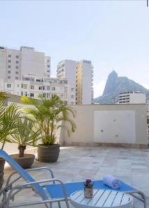 un patio con 2 sillas y una mesa y algunos edificios en Ótima Localização, reformado e com piscina!, en Río de Janeiro
