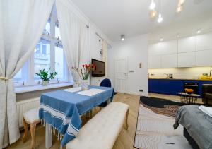 ein Wohnzimmer mit einem Tisch und einer Küche in der Unterkunft Apartament Żurawia street in Warschau