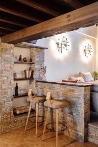 a kitchen with a brick wall and a table with stools at Volos luxury maisonette-Pelion view in Volos
