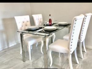 a dining room table with white chairs and a bottle of wine at MI CAPRICHO A12 BEACHFRONT - Apartment with sea view- Costa del Sol in Sitio de Calahonda