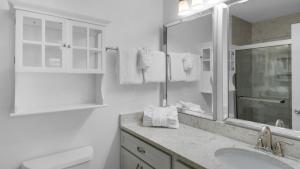 a white bathroom with a sink and a mirror at Blue Nine 2 in Panama City Beach +87 photos