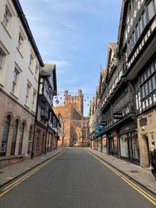 uma rua da cidade vazia com um castelo ao fundo em The Lodge Chester - luxury apartment for two, with free parking! em Hough Green