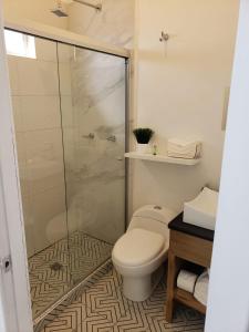 a bathroom with a toilet and a glass shower at Departamentos L in Cuauhtémoc