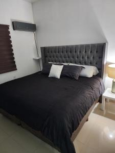 a bedroom with a large bed with a large headboard at Departamentos L in Cuauhtémoc