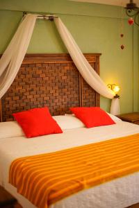 a bedroom with a large bed with red pillows at La Escondida Hotel Boutique in Zacatlán