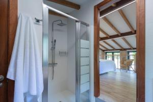 a bathroom with a shower with a glass door at Entre Os Ríos - Casa Rural y Enoturismo in A Pobra do Caramiñal