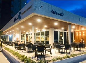 ein Restaurant mit Tischen und Stühlen am Abend im Freien in der Unterkunft Salinas Exclusive Resort in Salinópolis