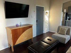 a living room with a flat screen tv and a chair at The Lofts at Myrtle in El Paso