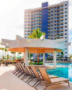 - un groupe de chaises et une piscine dans un complexe dans l'établissement Salinas Exclusive Resort, à Salinópolis