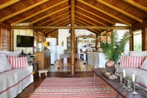 a living room with a couch and a table at Casa Portunhol PE NA PRAIA DO RIO VERDE TRANCOSO in Trancoso