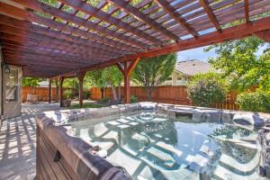a hot tub in a backyard with a wooden pergola at Redwick in Meridian