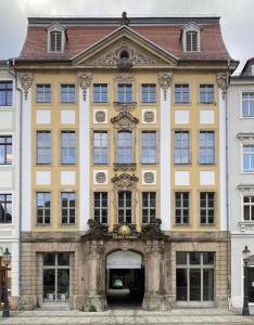 a large yellow building with an entry way at Hotel Sonne in Zittau