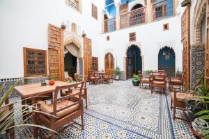 een binnenplaats met tafels en stoelen in een gebouw bij Dar Shaeir in Rabat